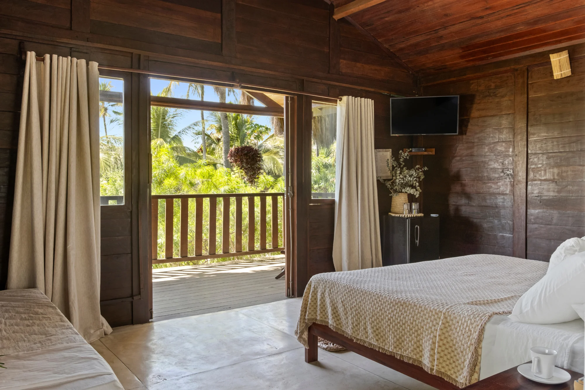 suíte superior cama casal tv e saída frente jardim